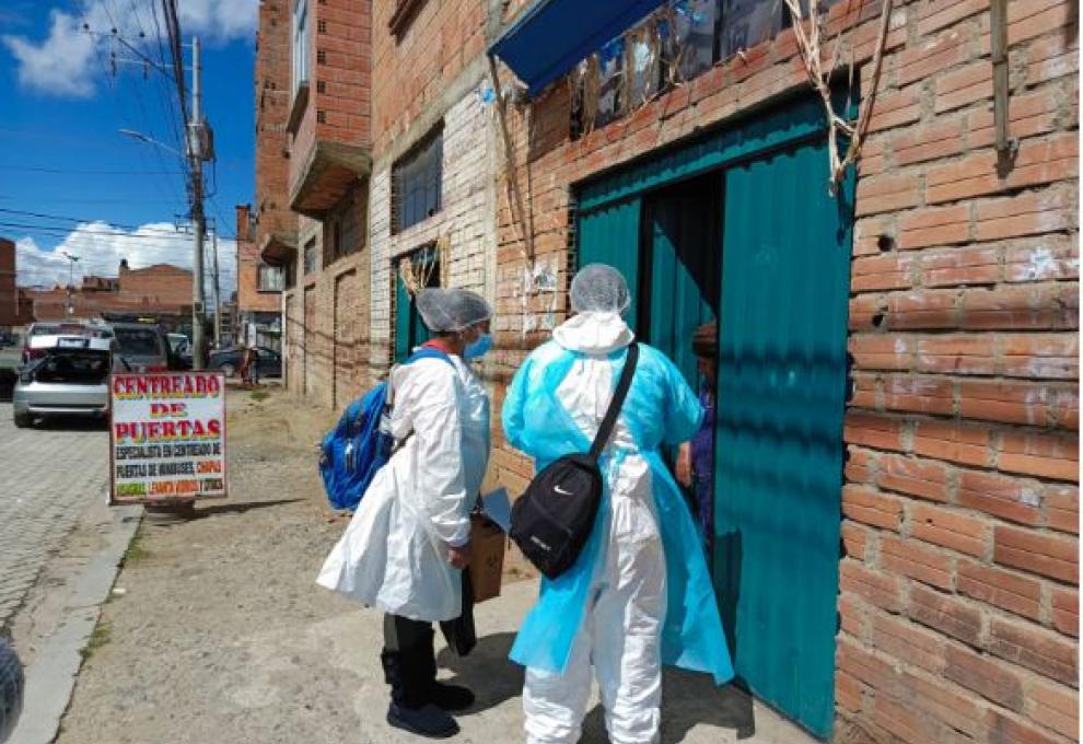 Un equipo de salud en la puerta de una vivienda en El Alto. Foto: Gobierno Municipal de El Alto. 